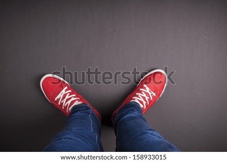 Feet concept with red shoes on black background with space for text or symbol