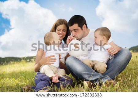 Happy family playing with balloons in nature
