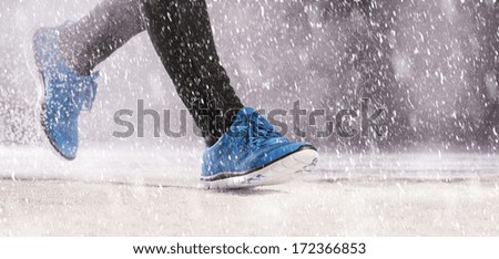 Athleteman is running during winter training outside in cold snow weather.