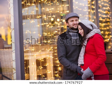 Young pregnant couple portrait in winter town