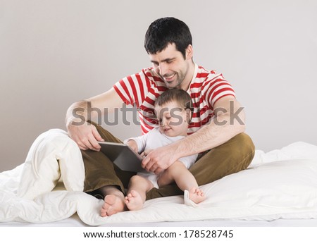 Portrait of a father with his son in bed