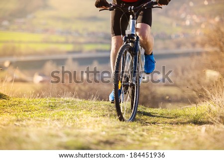 Detial of cyclist man legs riding mountain bike on outdoor trail in nature