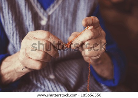 Hands of senior woman knitting with wool and knitting needles