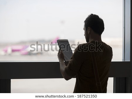 Young man at the airport waiting for his plane