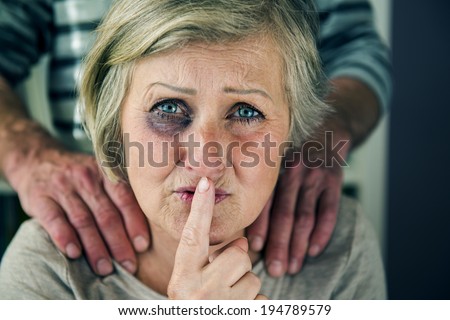 Portrait of woman victim of domestic violence. Man abusing senior woman with black eye-