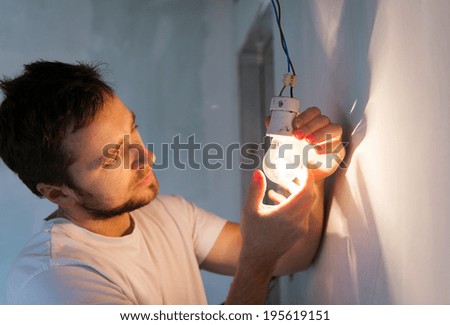 Electrician installing light in a new house