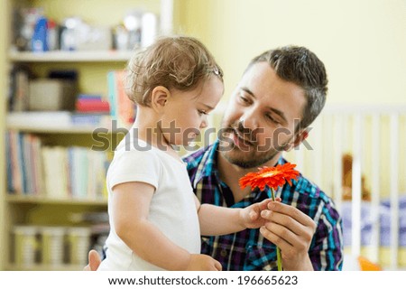 Portrait of a happy father with flower and his little daughter