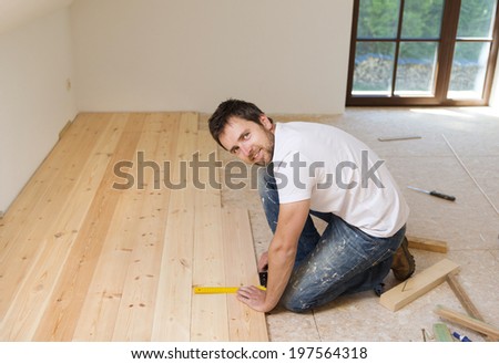 Handyman installing wooden floor in new house