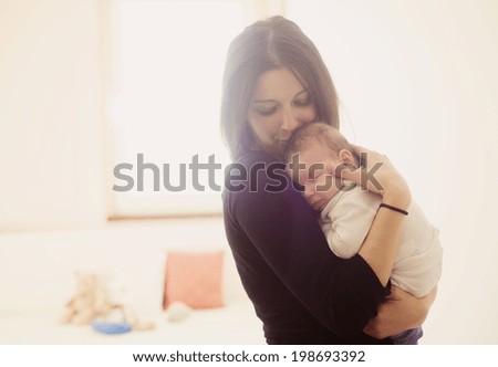 Young mother is holding her little baby