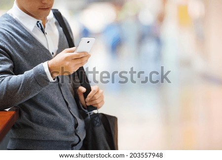 Handsome young man in shopping mall using mobile phone