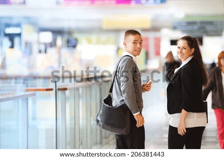 Businessman and businesswomen having a meeting in shopping mall. Woman is pregnant.