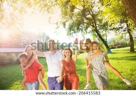 Group of five teenage friends having fun in park