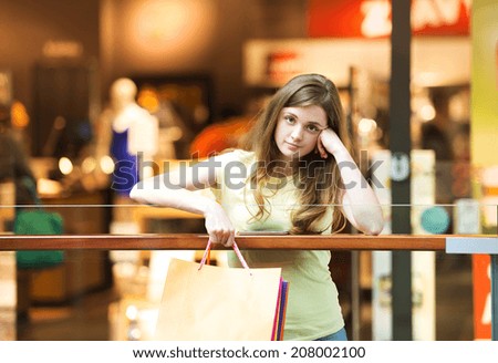 Tired girl with shopping bags in mall