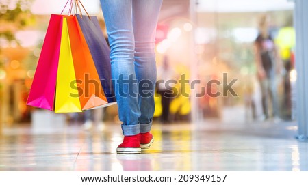 Shopping time, closeup of teenage girl legs with shopping bags at shopping mall