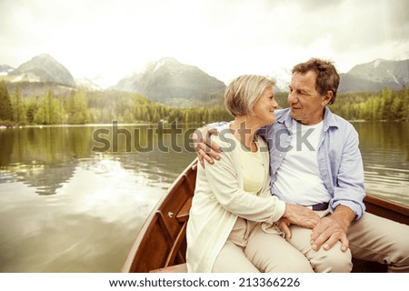 Senior couple hugging on boat on mountain tarn