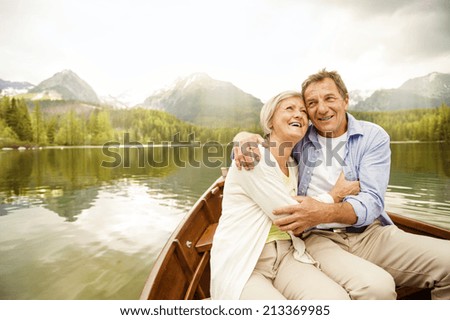 Senior couple hugging on boat on mountain tarn