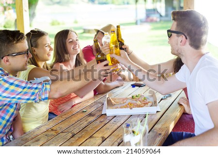 Group of happy friends drinking and having fun in pub garden