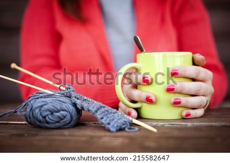 Close up portrait of winter girl knitting and drinking hot drink