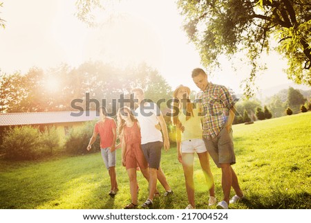 Group of six teenage friends having fun in park