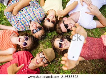 Group of young people having fun in park, lying on the grass