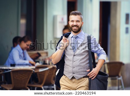 Handsome hipster modern businessman with briefcase walking in town