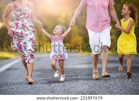 Happy family having fun during the walk on the road
