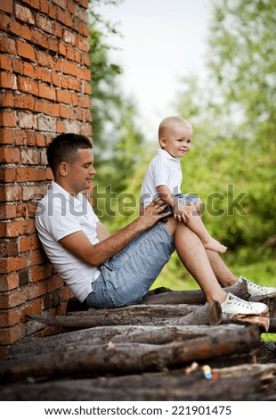 Happy father with little son spending time in nature by the old house