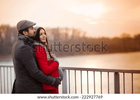 Young pregnant couple portrait in winter town