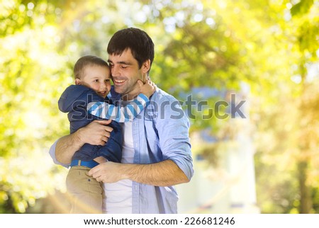 Father and son spending time together hugging in sunny nature
