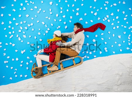 Young couple on sledge having fun