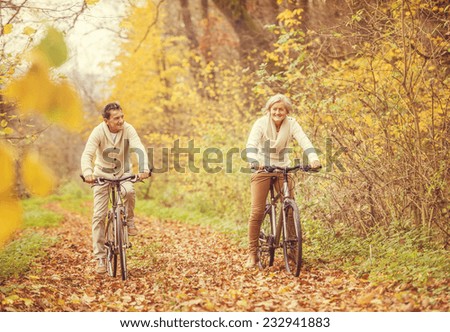 Active seniors on bikes in autumn nature