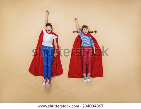 Children are playing as superheroes with red coats