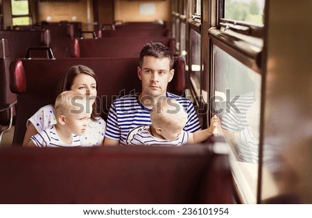 Family with two children travel in retro train.