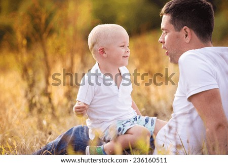 Young father and son enjoying life together. They are playing outside in nature