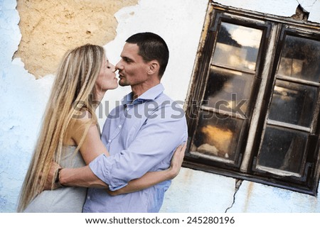 Happy young couple in love hugging in front of an old
