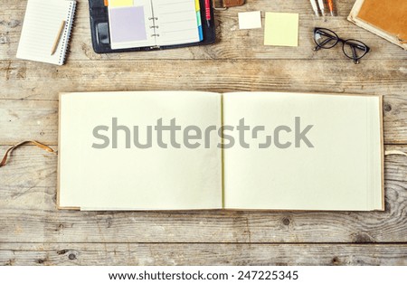 Mix of office supplies on a wooden table background. View from above.