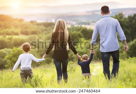 Happy young family spending time together outside in green nature.