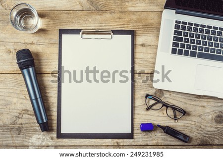 Composition of office gadgets and supplies on a wooden desk background. View from above.