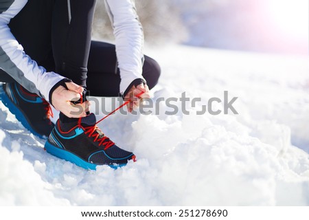 Legs of young sportsman jogging outside in a winter park