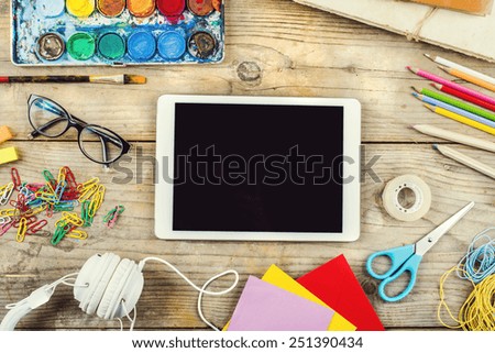 Desk of an artist with lots of stationery objects. Studio shot on wooden background.