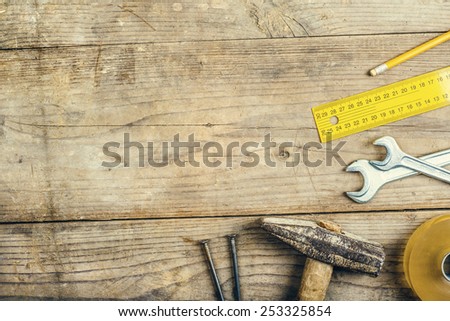 Desk of a carpenter with different tools. Studio shot on a wooden background.