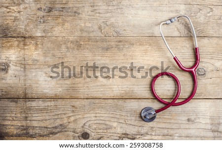 Workplace of a doctor. Stethoscope on wooden desk background.
