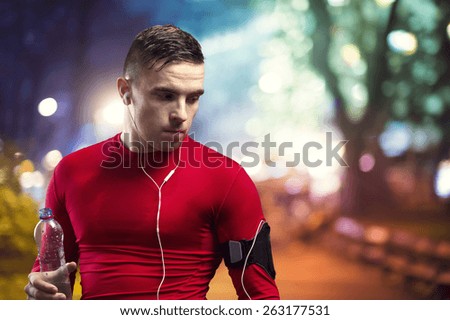 Young sportsman jogging in the city at night
