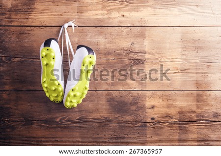 Pair of sneakers hang on a nail on a wooden fence background
