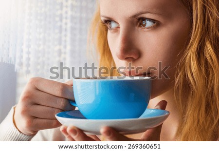 Beautiful woman sipping coffee from her cup