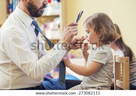 Young father getting his little daughter ready in a morning