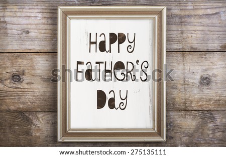 Rectangle picture frame with Happy fathers day sign laid on wooden floor backround.