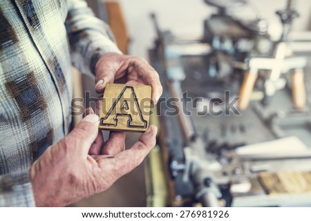 Senior man holding a letter that is used for engraving