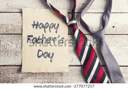 Happy fathers day sign on paper and colorful ties laid on wooden floor backround.