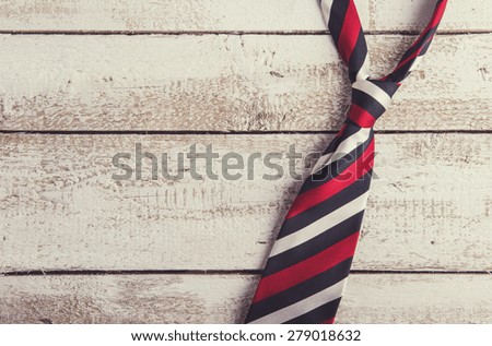 Fathers day composition of colorful tie laid on wooden floor backround.